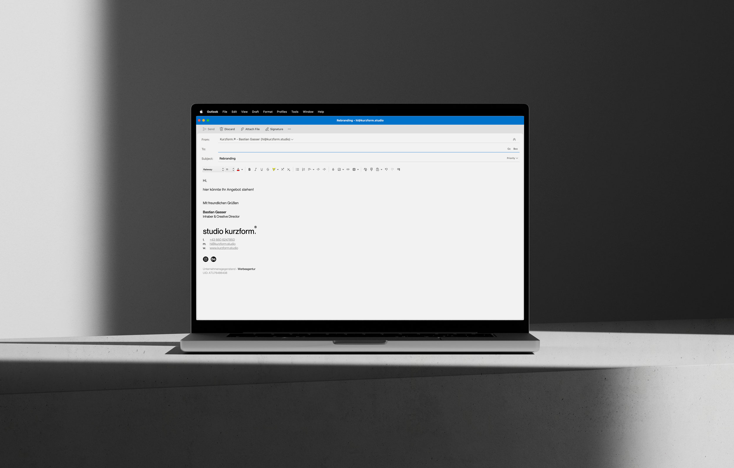 Laptop mit geöffneten Outlook und der Email Signatur von Kurzform in monochromen Umgebung mit harten Schatten