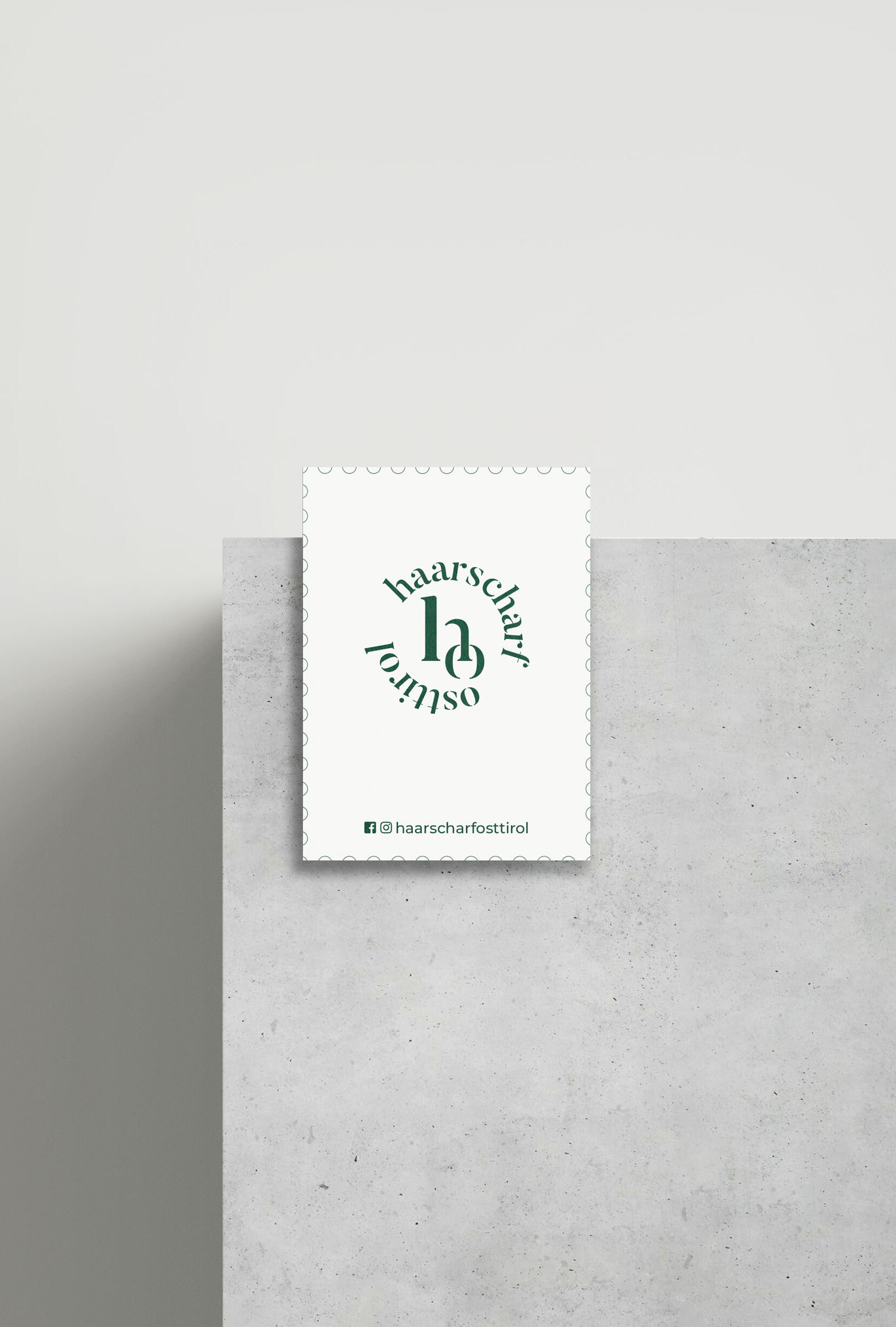 Haarscharf Osttirol Visitenkarte auf einer Betonkante mit weißem Hintergrund
