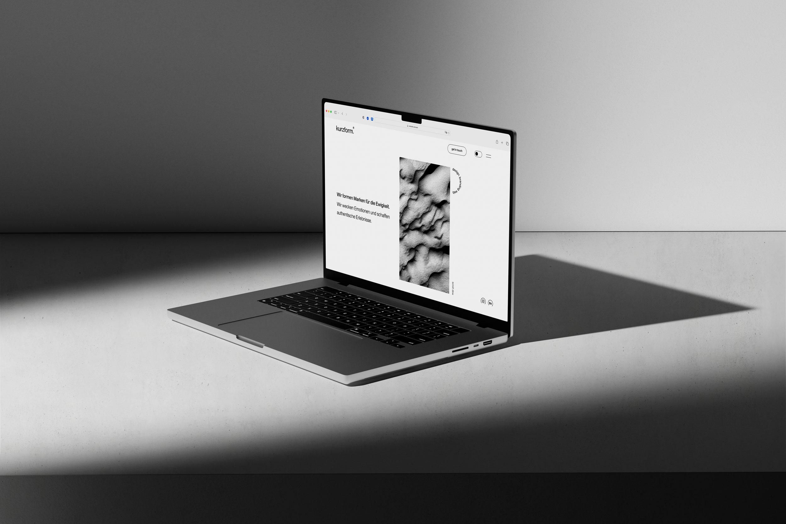 Laptop mit geöffneten Hero Section von der Website von Kurzform in monochromen Umgebung mit harten Schatten